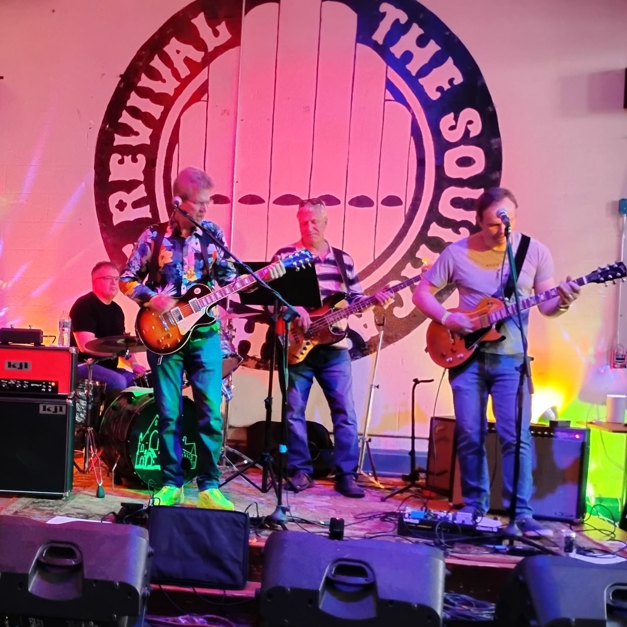 3 Wire Monkey performing together under colorful stage lights