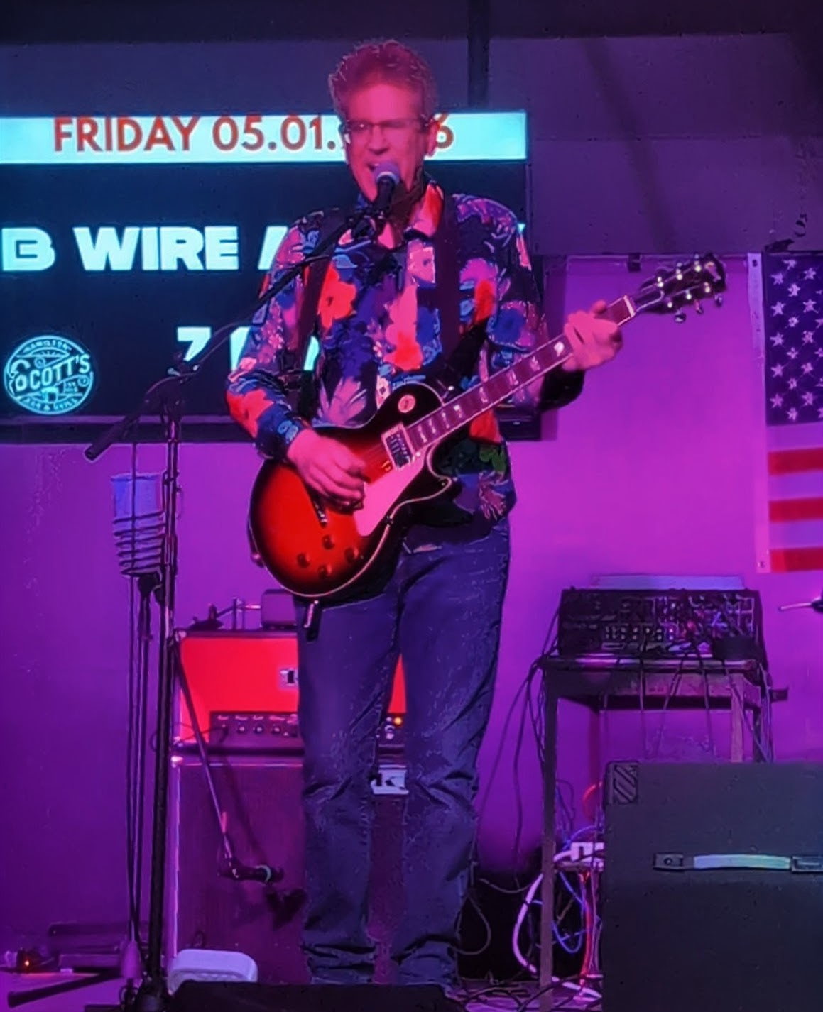 3 Wire Monkey guitarist playing a red guitar on stage